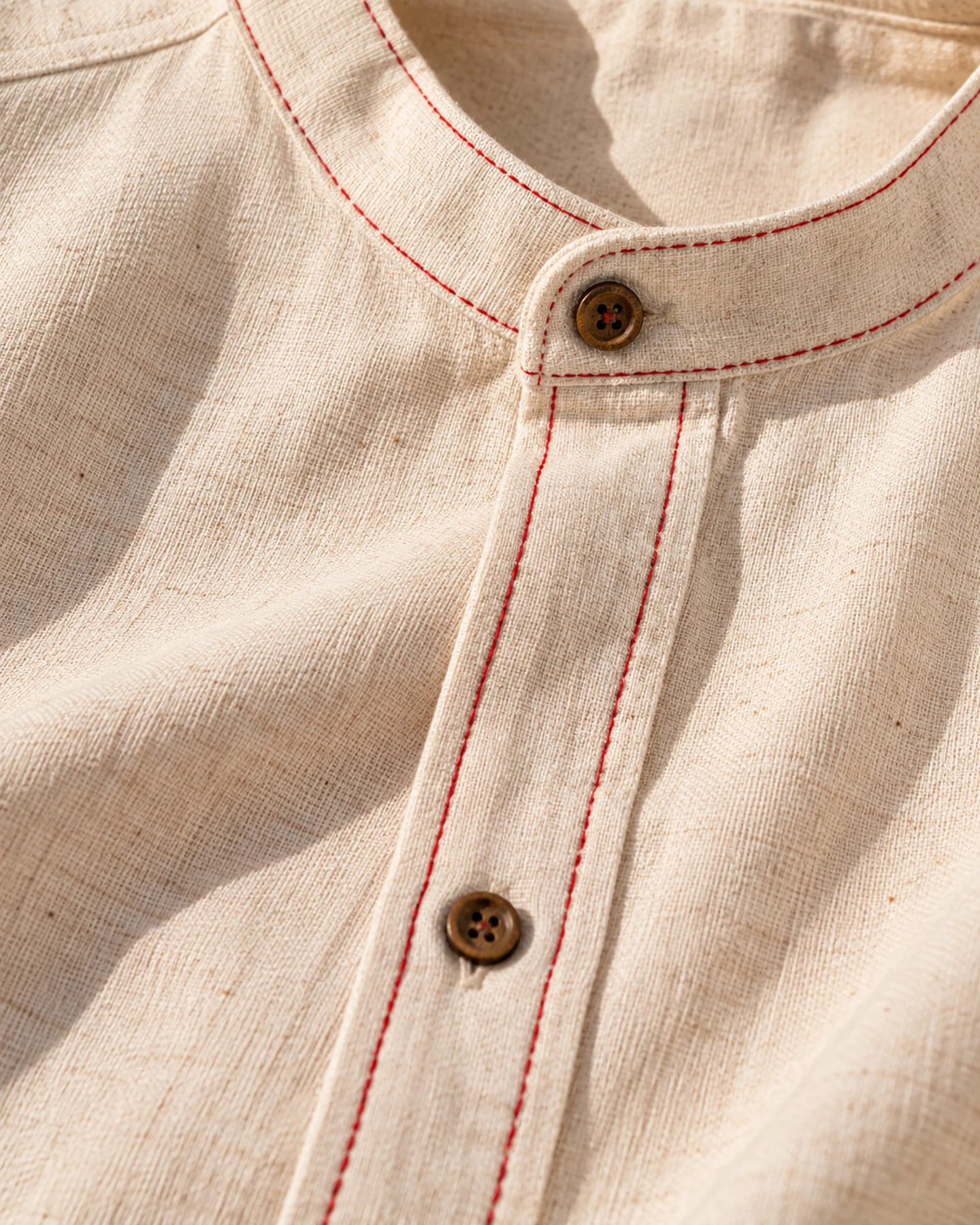 Camisa Mykonos en crudo con bordado rojo, en macro, la textura del material