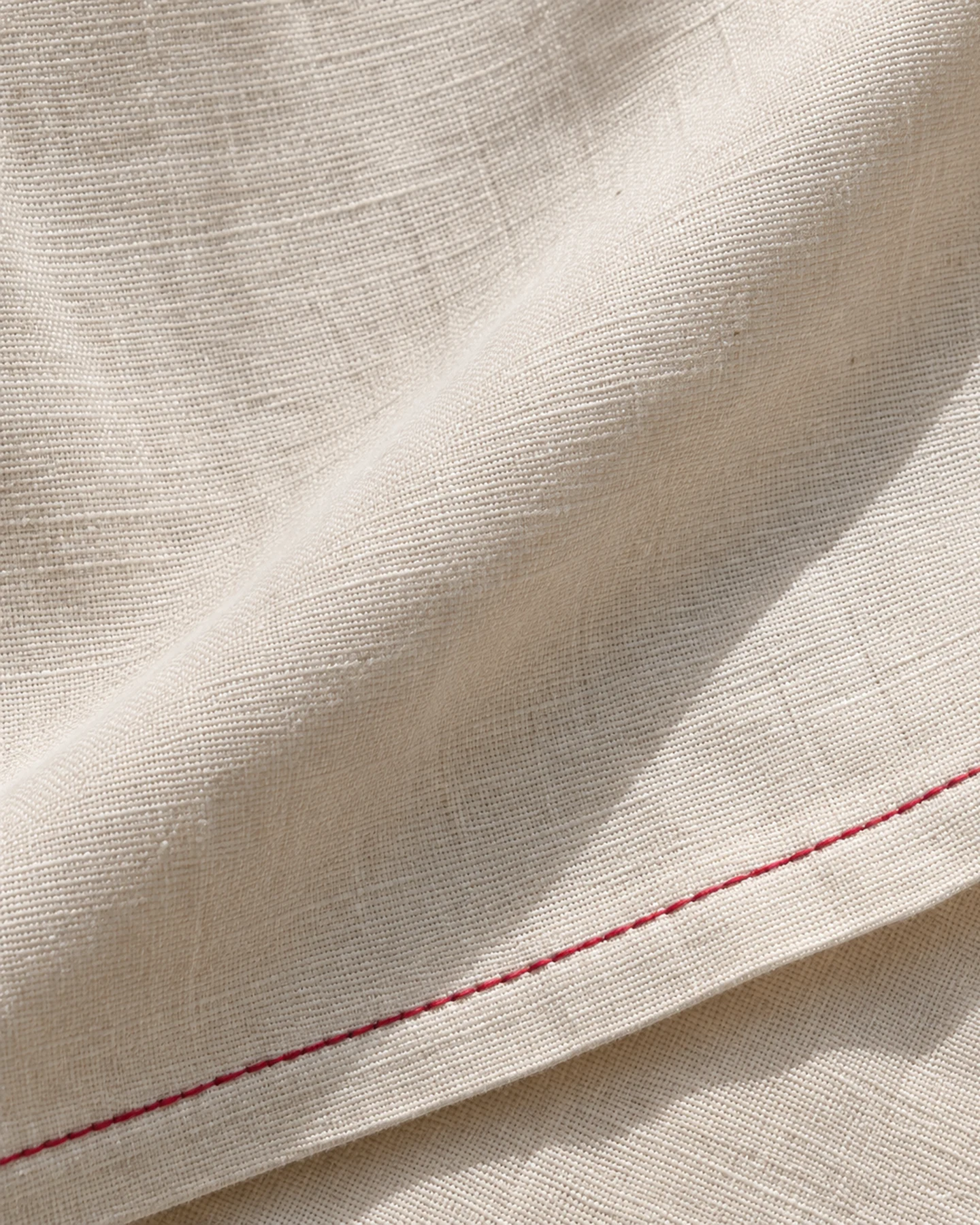Kimono Paris en crudo con bordado rojo, en macro, la textura del material