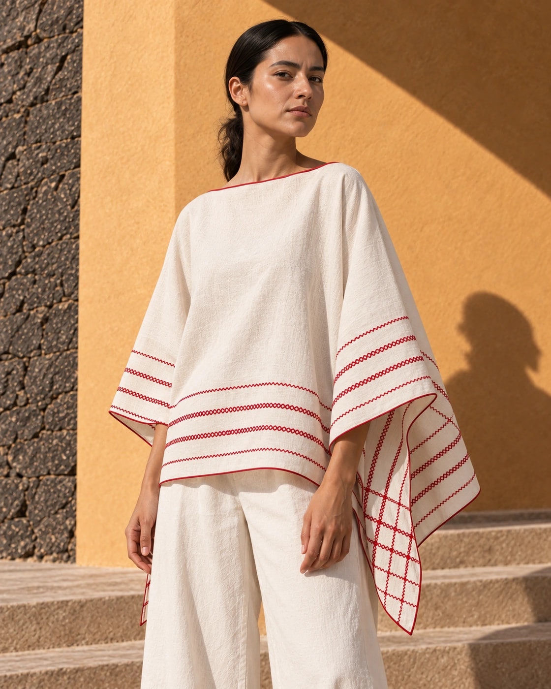 Poncho Marbella de lino en crudo con bordado rojo, de cerca, la caída de la prenda