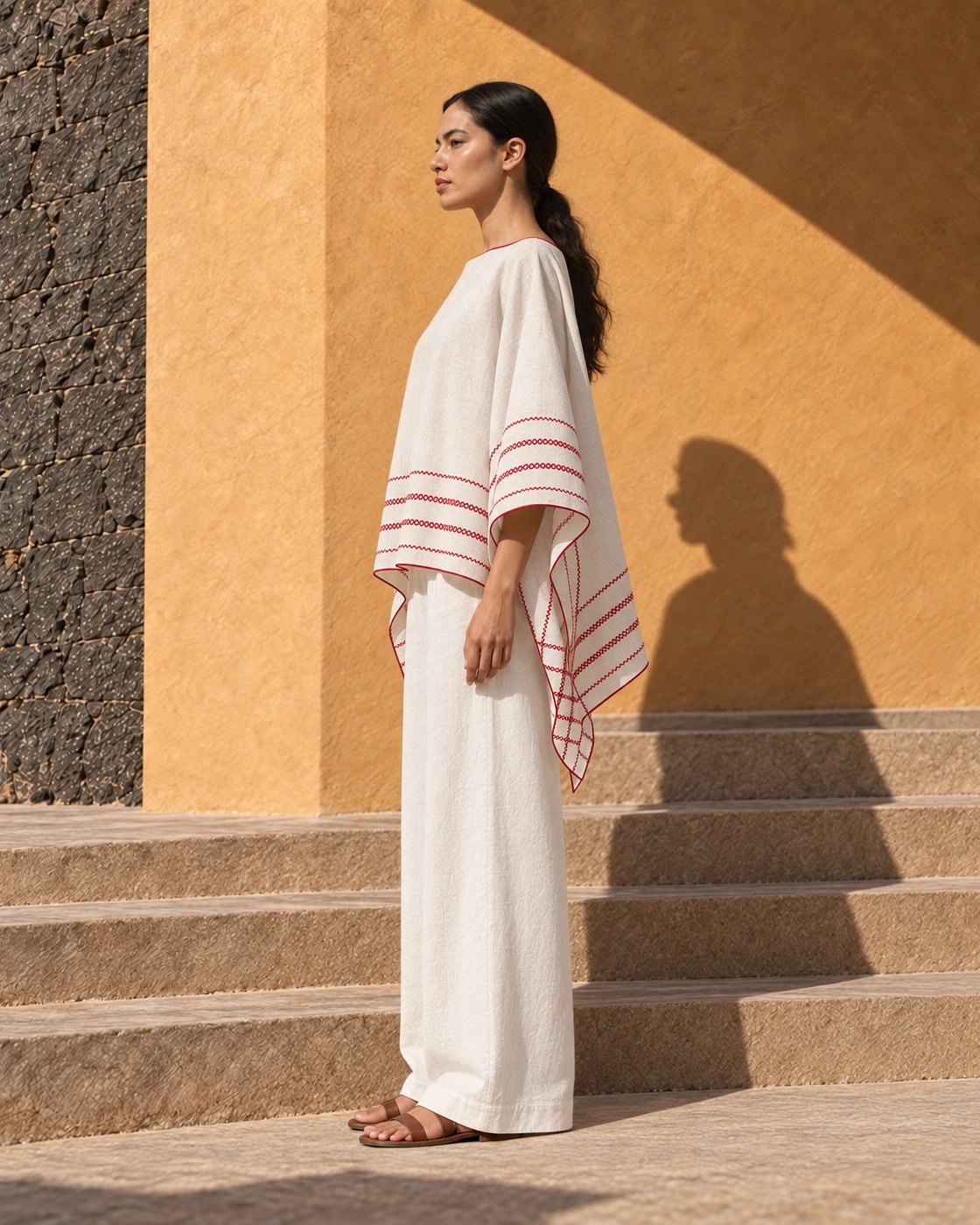 Poncho Marbella de lino en crudo con bordado rojo, de perfil