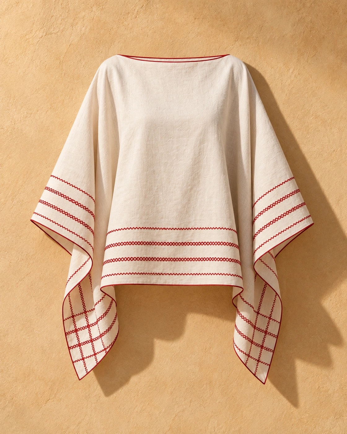 Poncho Marbella de lino en crudo con bordado rojo, de frente, sola